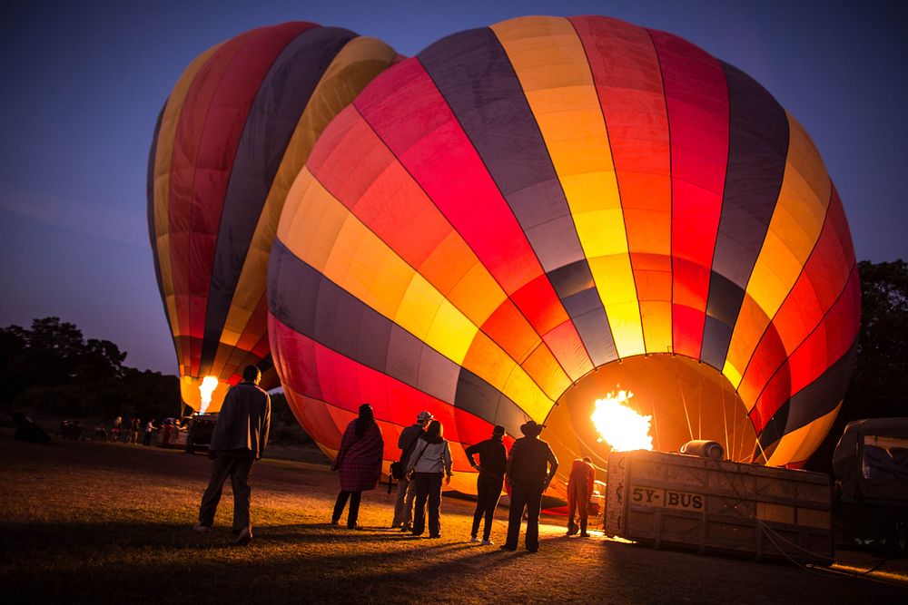 People watch gas is flared into Governor's Balloon Safari hot air balloon in preparation for flight over the Masai Mara…