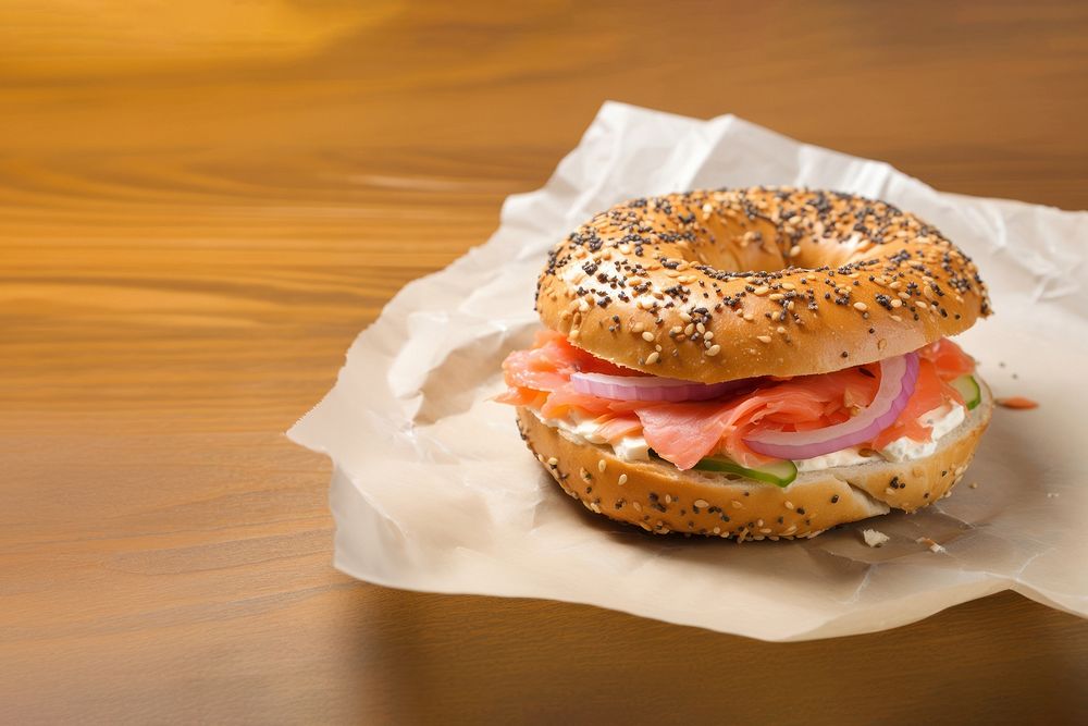 Close-up of Lox Bagel with onions on paper sheet.  