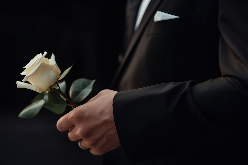 photo of hand in suit put white rose on a funeral casker. AI generated Image by rawpixel. 