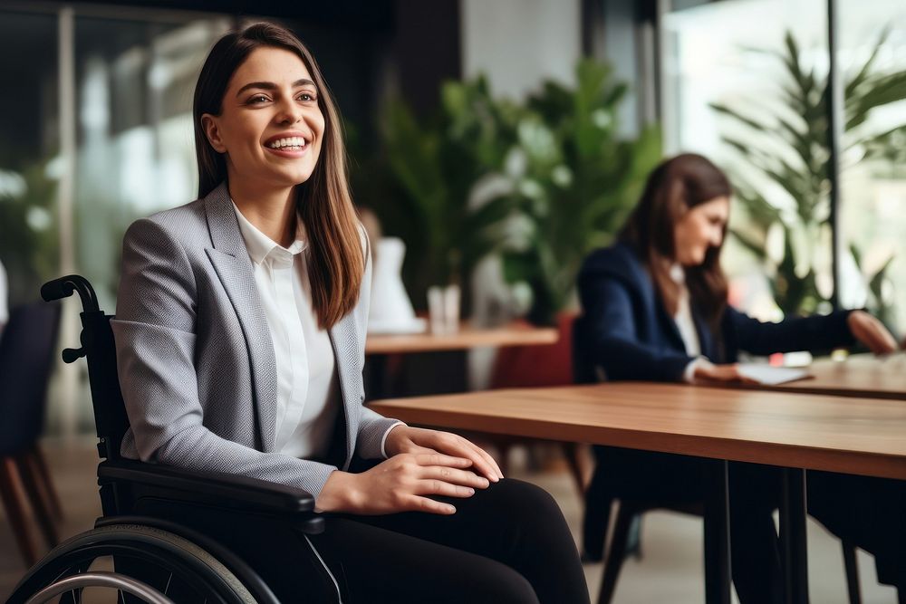 photo of a business woman in wheelchair presenting work in meeting room.  