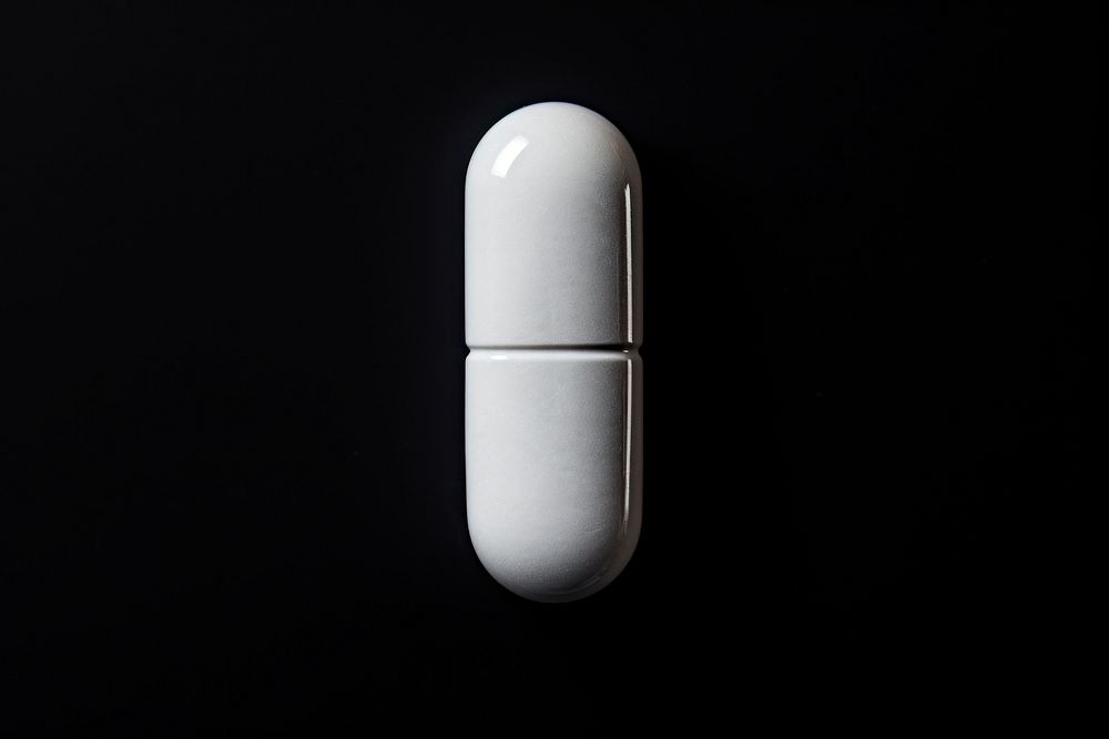 A pill drug black background electronics. AI generated Image by rawpixel.