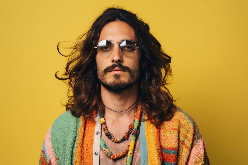 A man wearing hippy style outfit portrait sunglasses beard. 