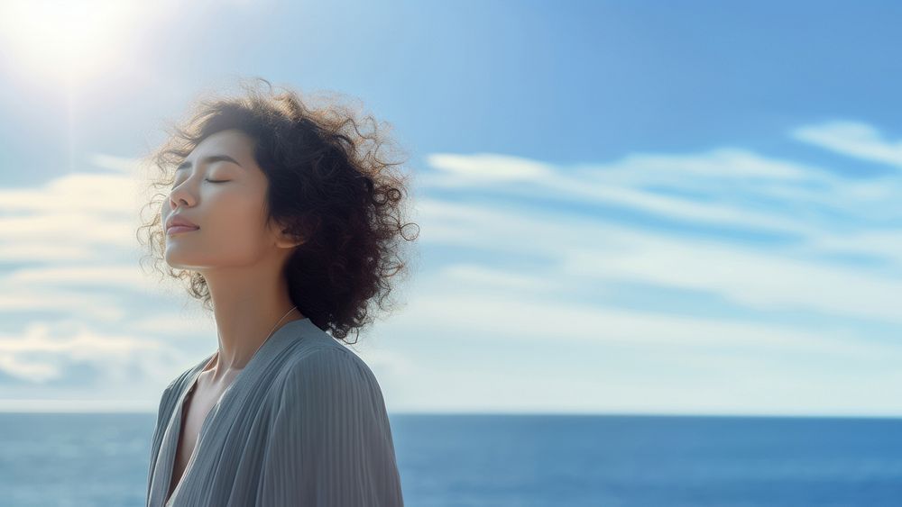 photo of woman praying with bluesky on the sea with blurred vision.  