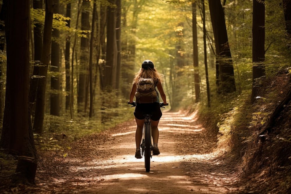 Woman biking forest trail bicycle vehicle cycling. AI generated Image by rawpixel.