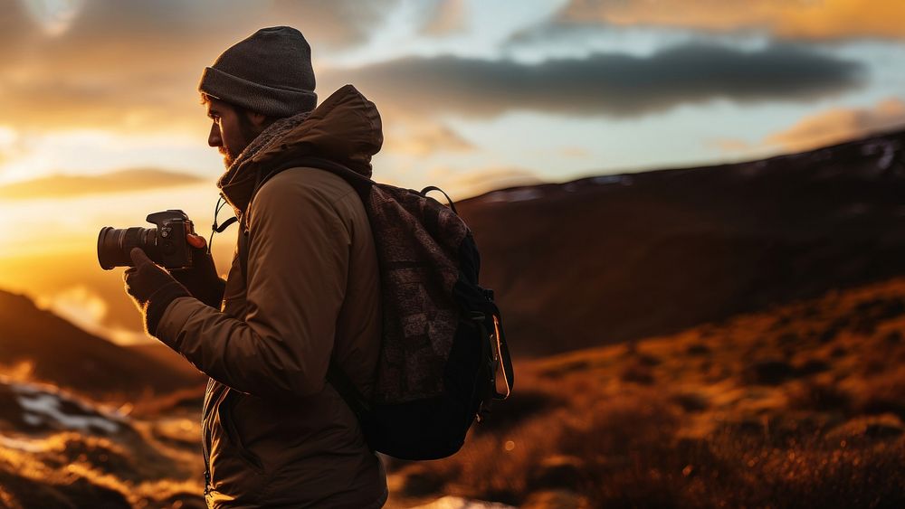 front-left view Photo of a man holding camera, taking picture in the wild in a chilly day. AI generated Image by rawpixel.