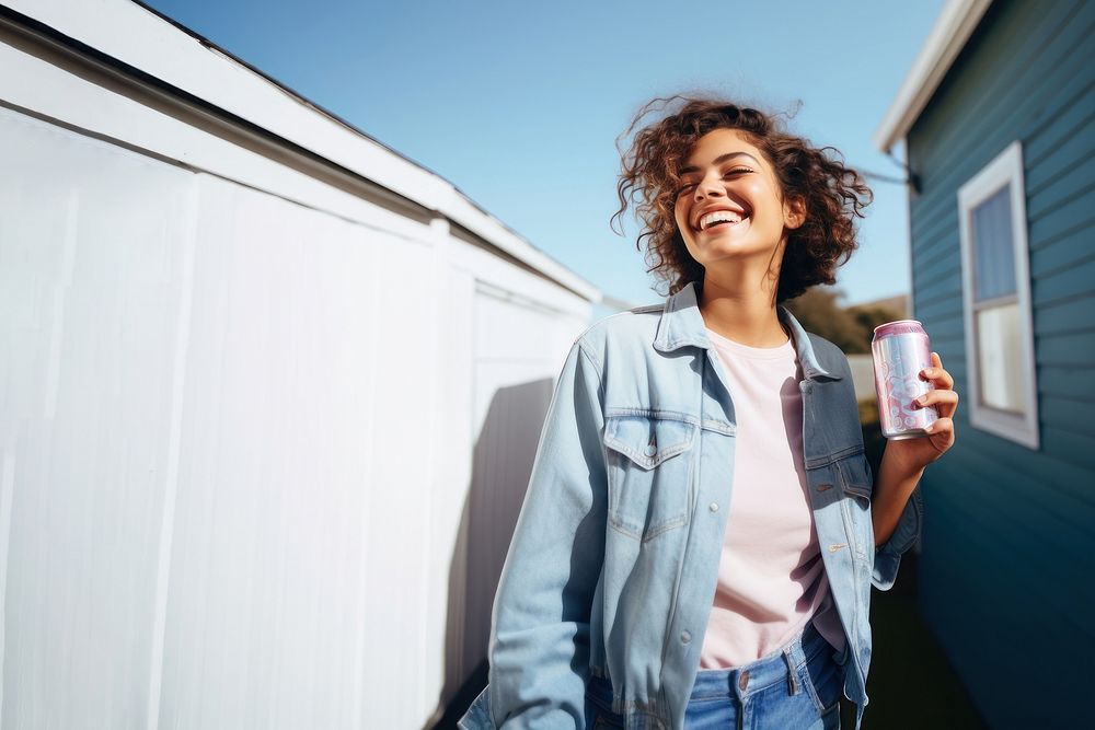 Portrait photo of a happy woman holding aluminum can looking at out side on minimal home. 