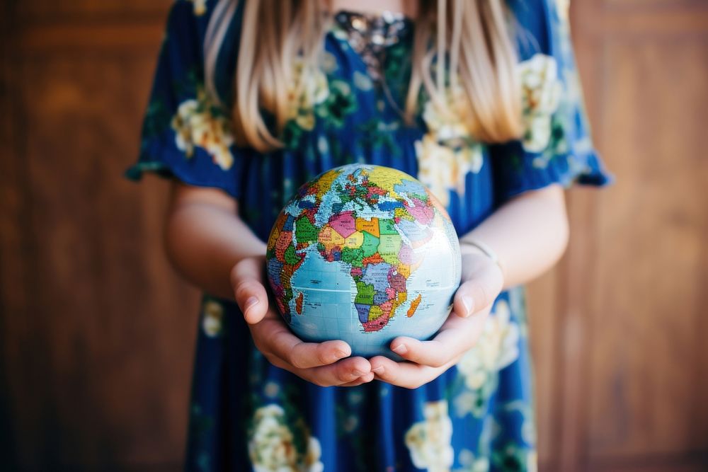 Girl holding a globe ball hand celebration creativity. 