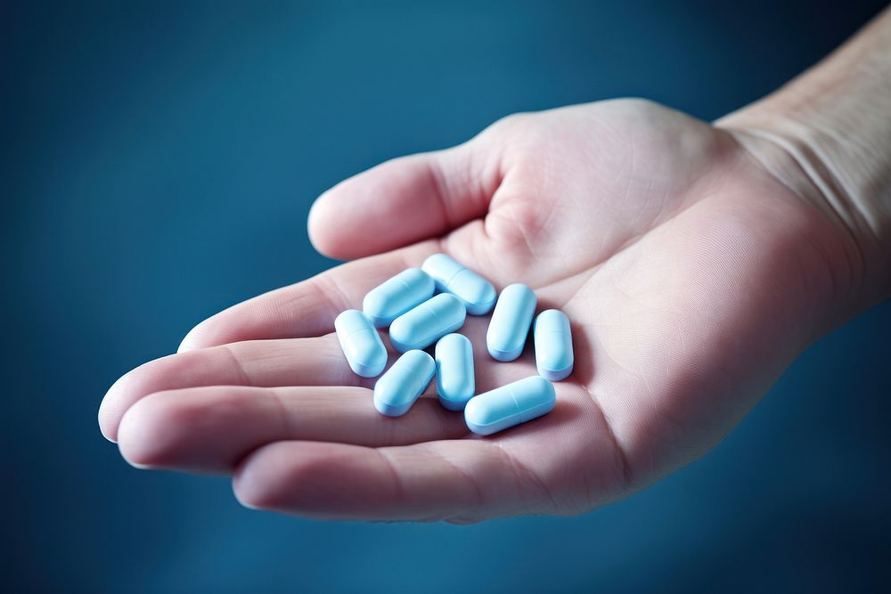 Pill hand photo blue. AI generated Image by rawpixel.