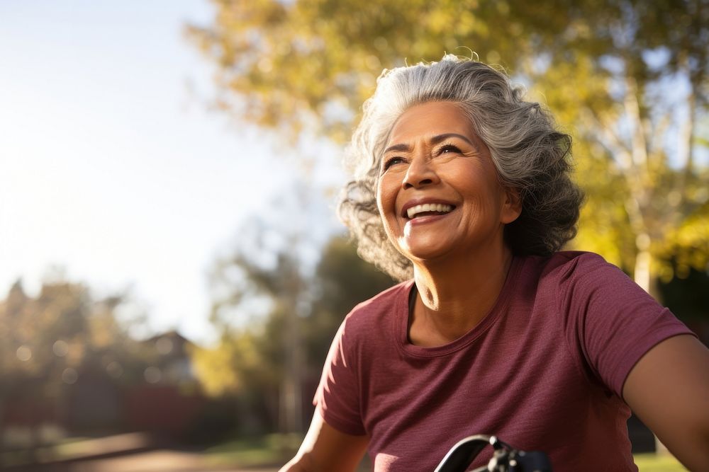 Senior hispanic woman riding a bicycle laughing adult smile. 