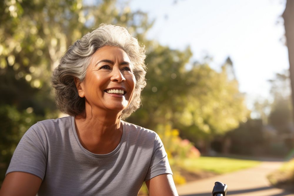 Senior hispanic woman riding a bicycle laughing adult smile. 