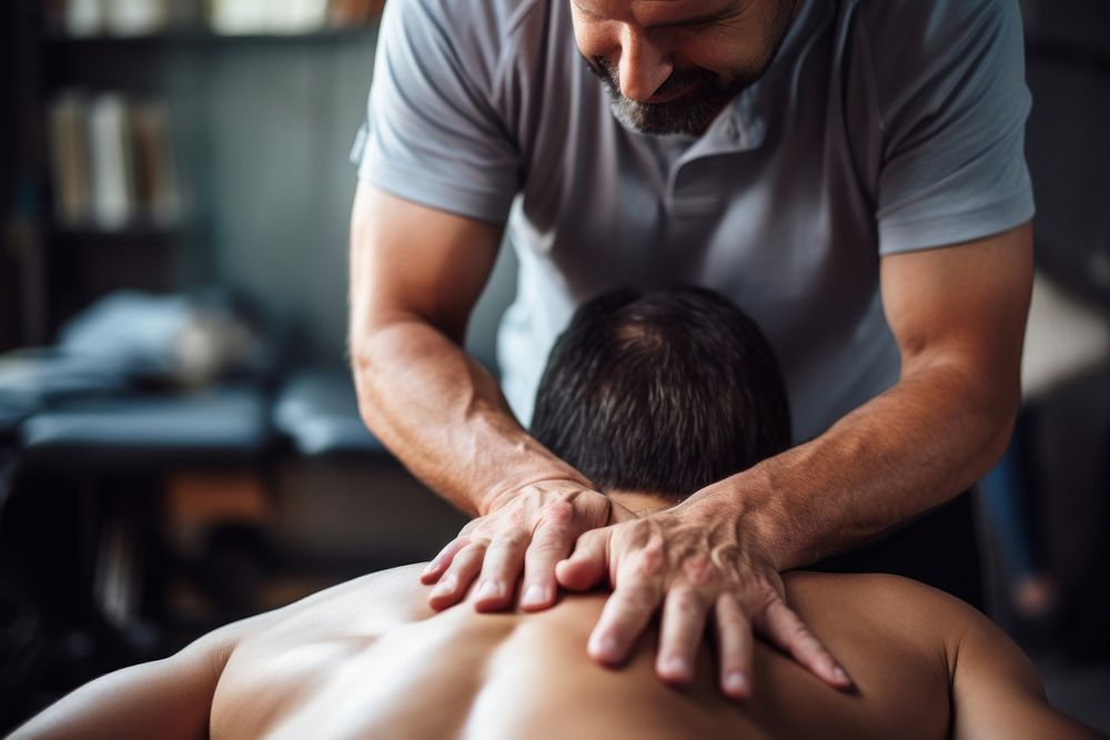 Therapist giving lower back sports massage patient adult male. AI generated Image by rawpixel.