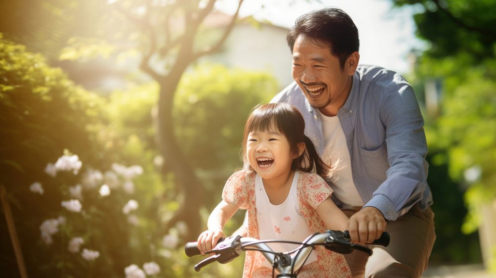 photo of an Asian father helps young daughter ride a bicycle. AI generated Image by rawpixel. 