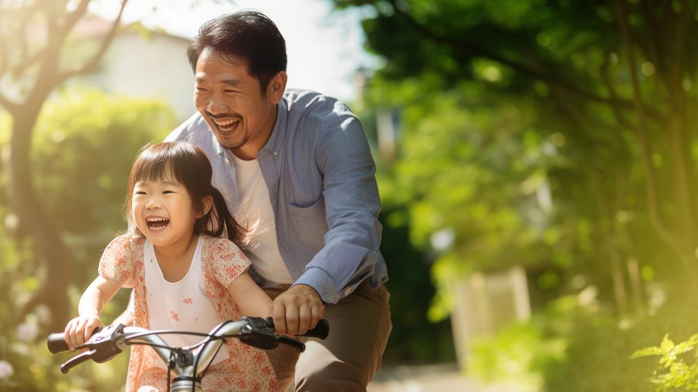 photo of an Asian father helps young daughter ride a bicycle. AI generated Image by rawpixel. 