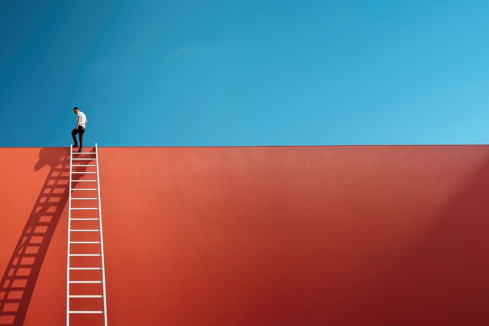 Photography of a man climbing a ladder to the roof.  