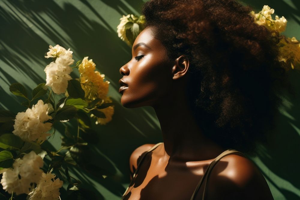 A dark-skinned woman portrait plant flower. 