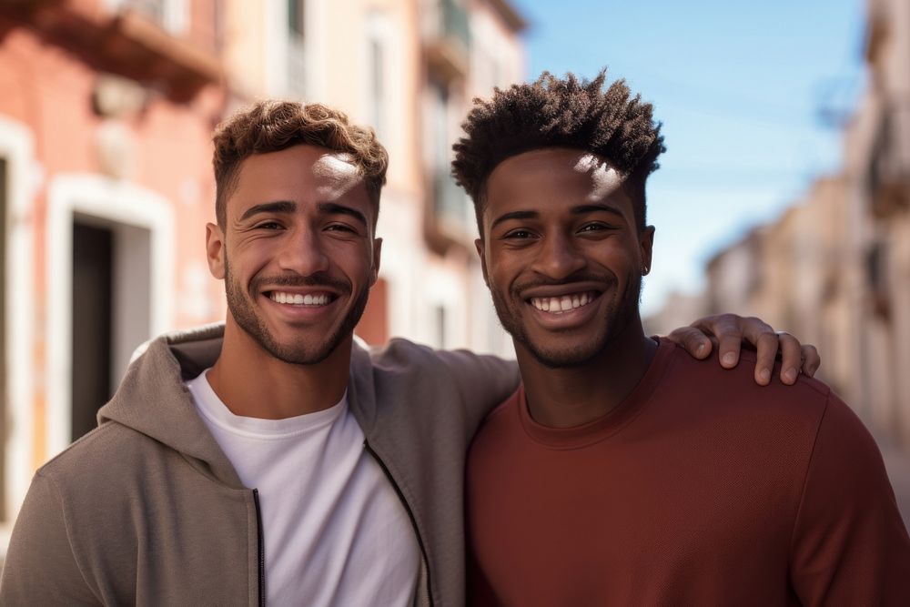 Gay couple laughing outdoors smiling. 