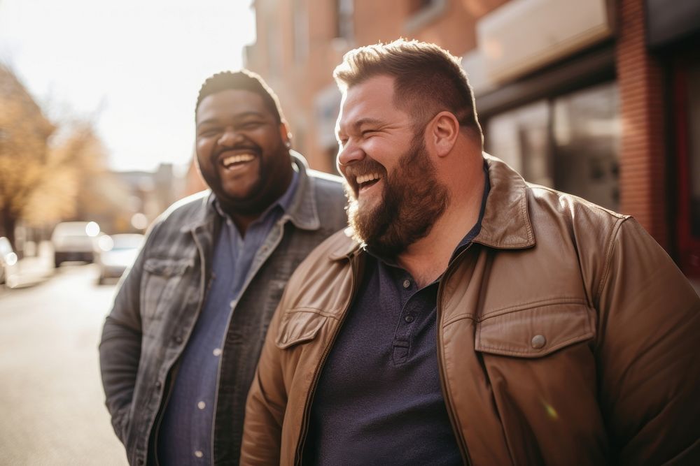 Gay couple laughing outdoors smiling. 