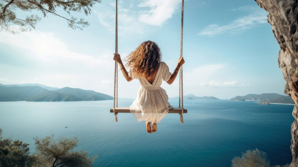 Traveler woman relaxing on swing above sea. AI generated Image by rawpixel. 