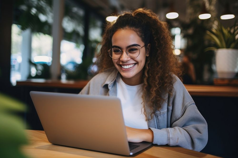 Hispanic woman using laptop smiling computer adult concentration. AI generated Image by rawpixel.