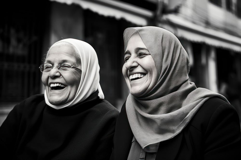 2 old women wearing hijab smiling together laughing portrait adult. 