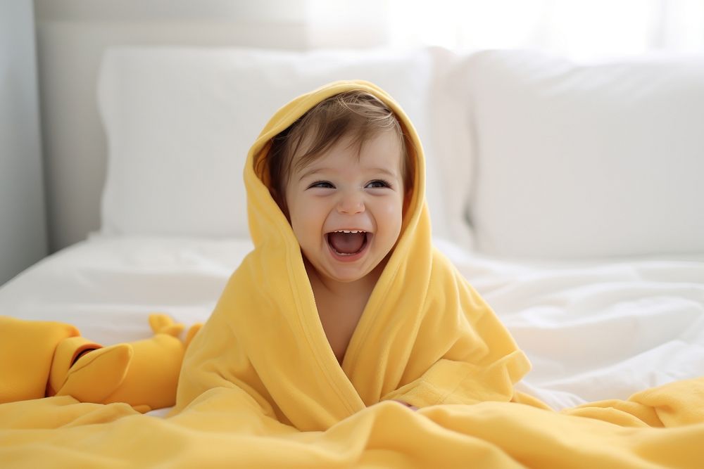 Baby wearing yellow hooded duck towel laughing blanket happy. AI generated Image by rawpixel.