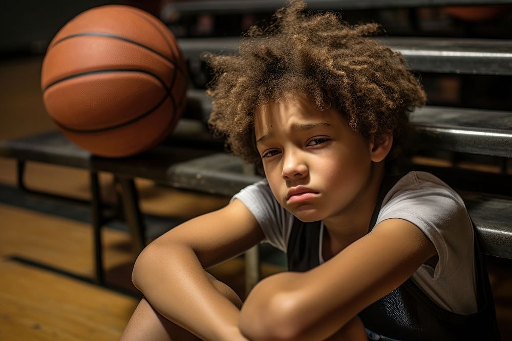 A Tired oung basketball player displaying stress worried sitting sports. AI generated Image by rawpixel.