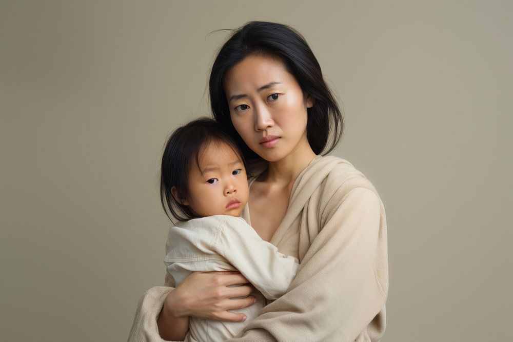 Stressed asian mother portrait hugging family. AI generated Image by rawpixel.
