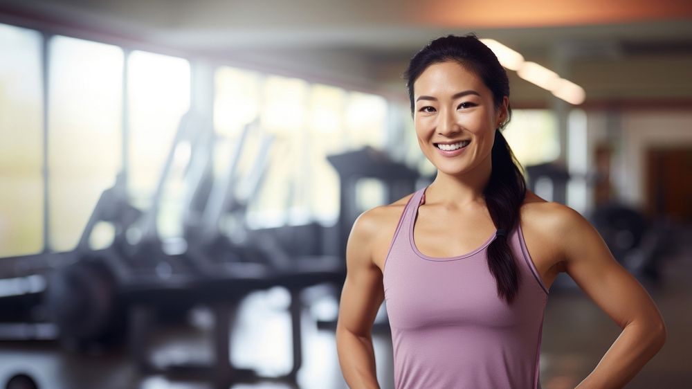 a photo of an Asian woman in sportswear standing in the gym. 