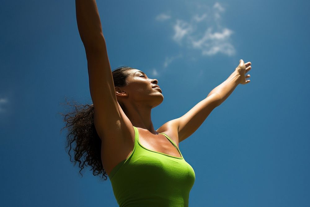 photo of mid-ages woman stretch the arms with bluesky and sun the green natual with blurred visio. AI generated Image by…