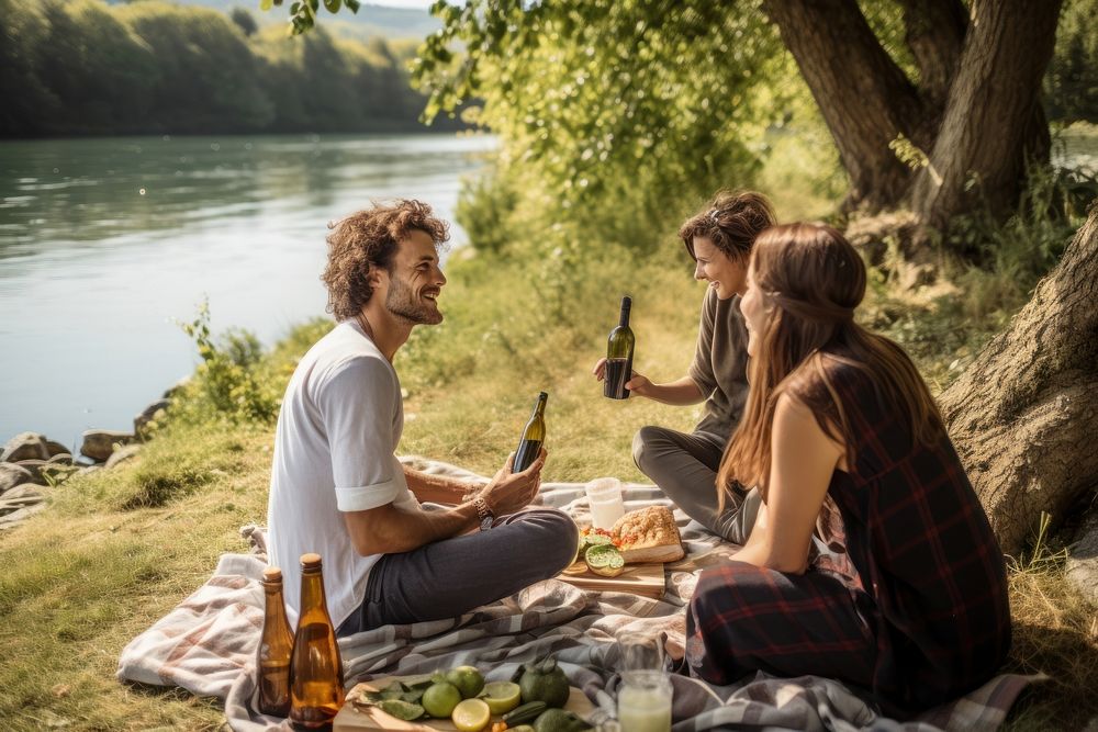 Diverse friends picnic near river outdoors nature plant. AI generated Image by rawpixel.
