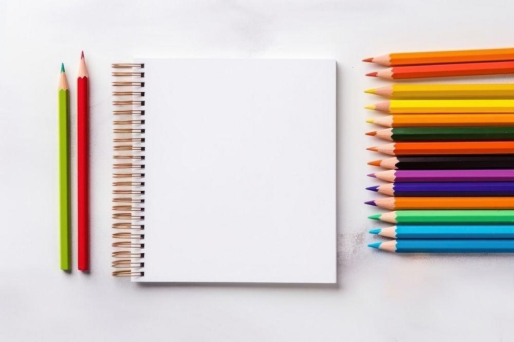 Pens pencils notebooks text publication arrangement. 