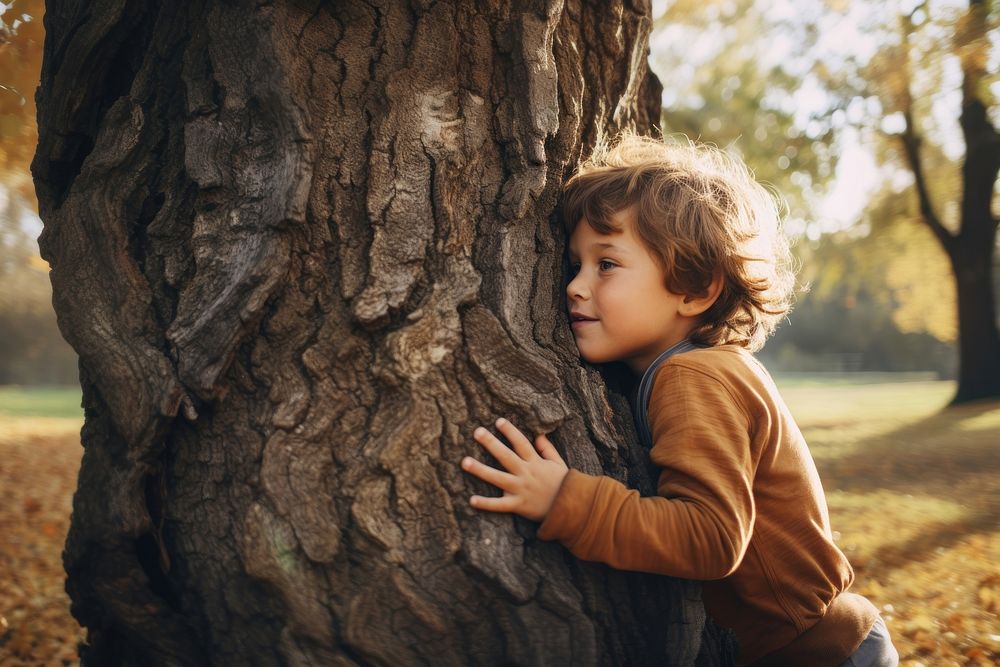 Little boy hugging a tree. 