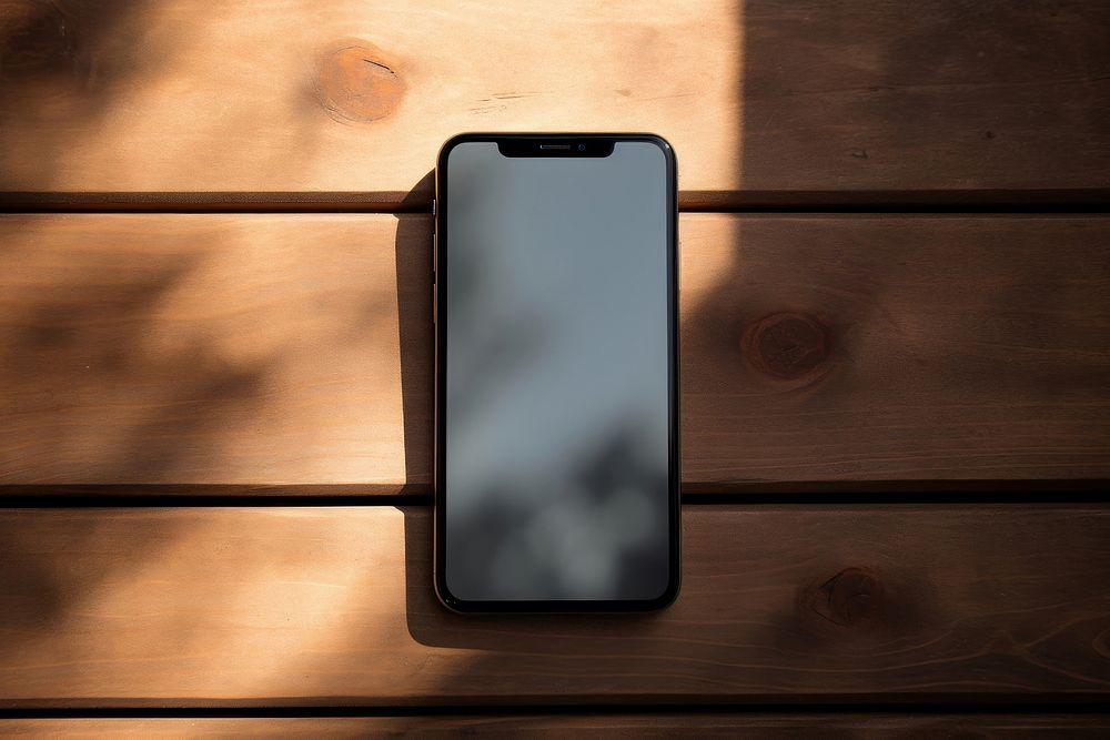 Smartphone shadow table wood. AI generated Image by rawpixel.
