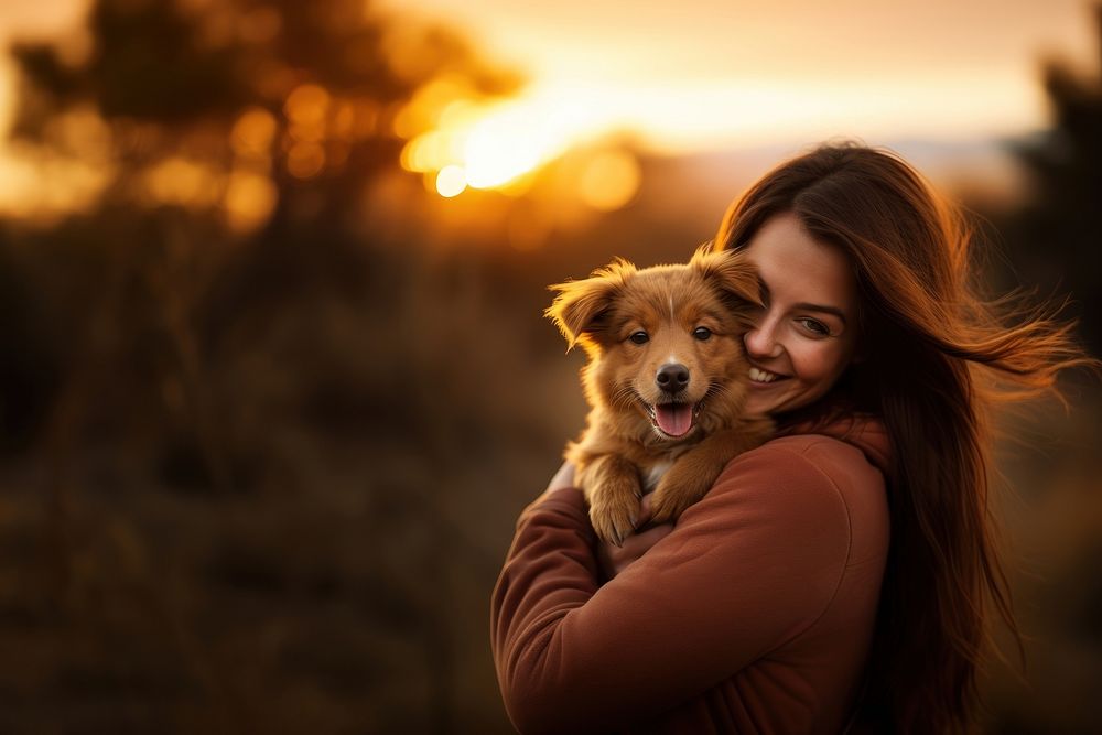 A woman holding a brown dog pitbull outdoors portrait mammal. 