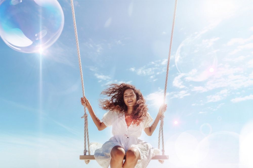 Woman on swing during summer with bubbles