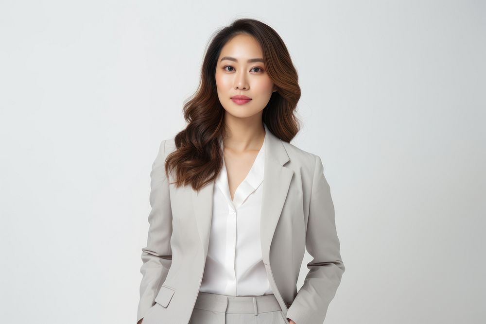 Confident woman in a gray suit, professional attire. Businesswoman with long hair, gray suit, and white shirt. Asian woman…