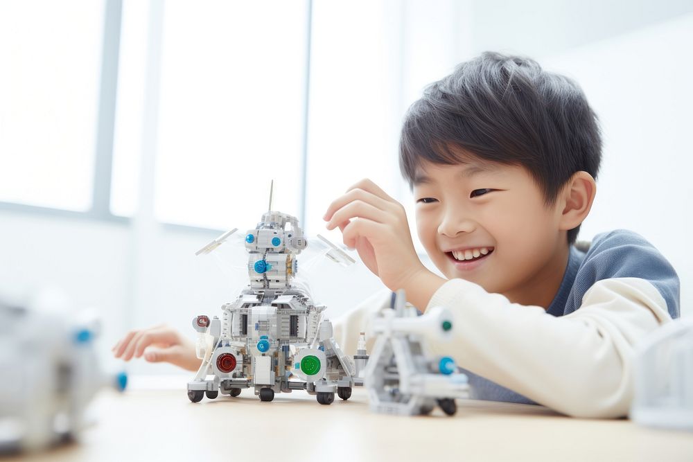 Asian cute boy smiling joyfully building a robot child toy technology. AI generated Image by rawpixel.