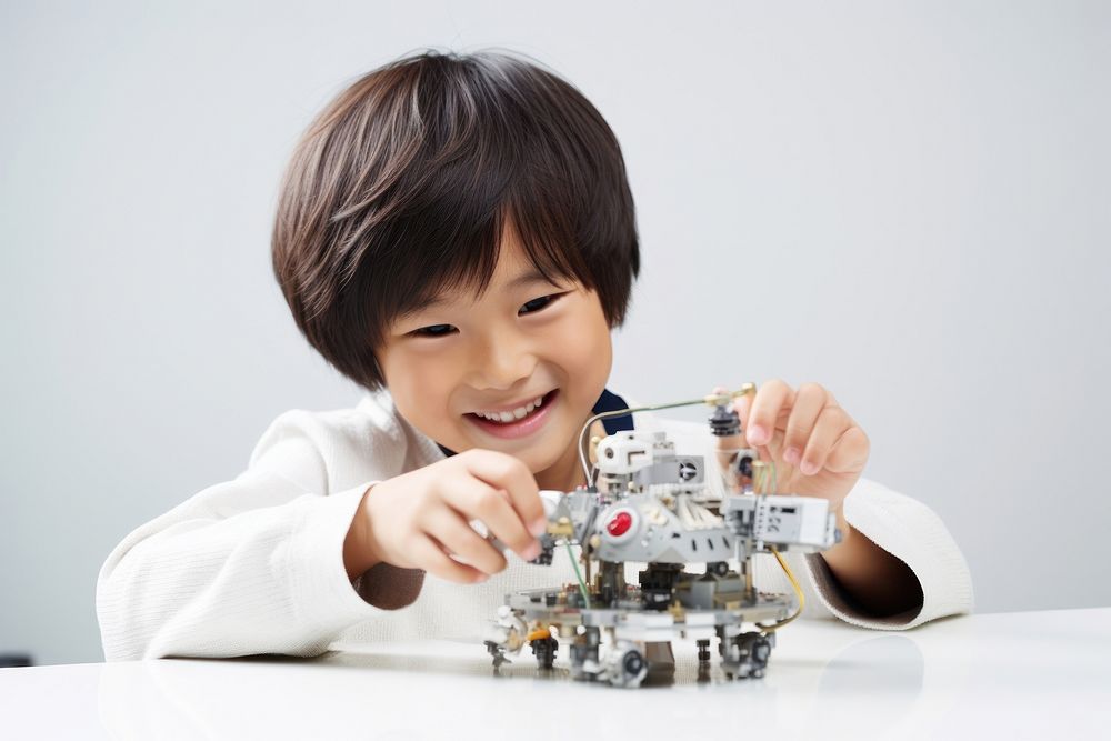 Asian cute boy smiling joyfully building a robot child smile happy. AI generated Image by rawpixel.