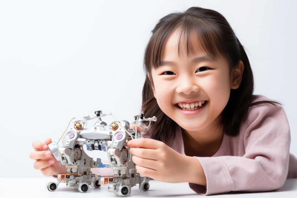 Asian cute girl smiling joyfully building a robot child toy happiness. AI generated Image by rawpixel.