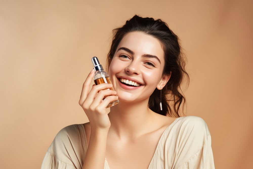 Smiling woman cosmetics applying perfume. 