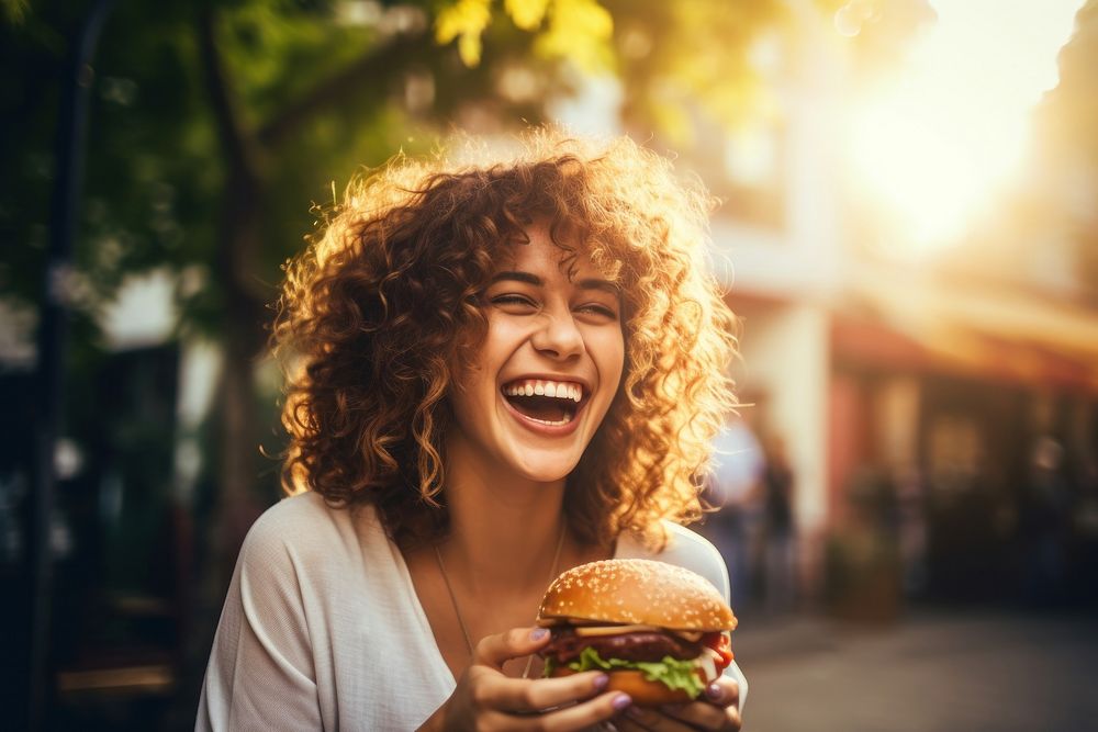 Eating burger laughing outdoors adult. 