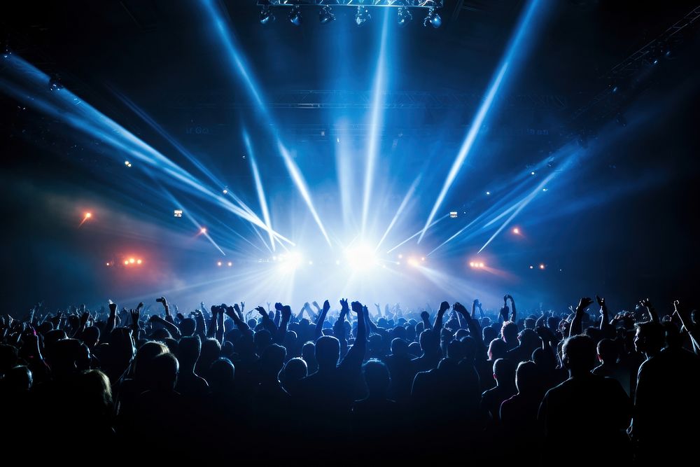 Glowing stage light illuminates cheering rock fans glowing concert adult. AI generated Image by rawpixel.