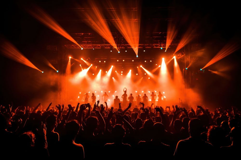 Glowing stage light illuminates cheering rock fans nightlife concert entertainment. AI generated Image by rawpixel.