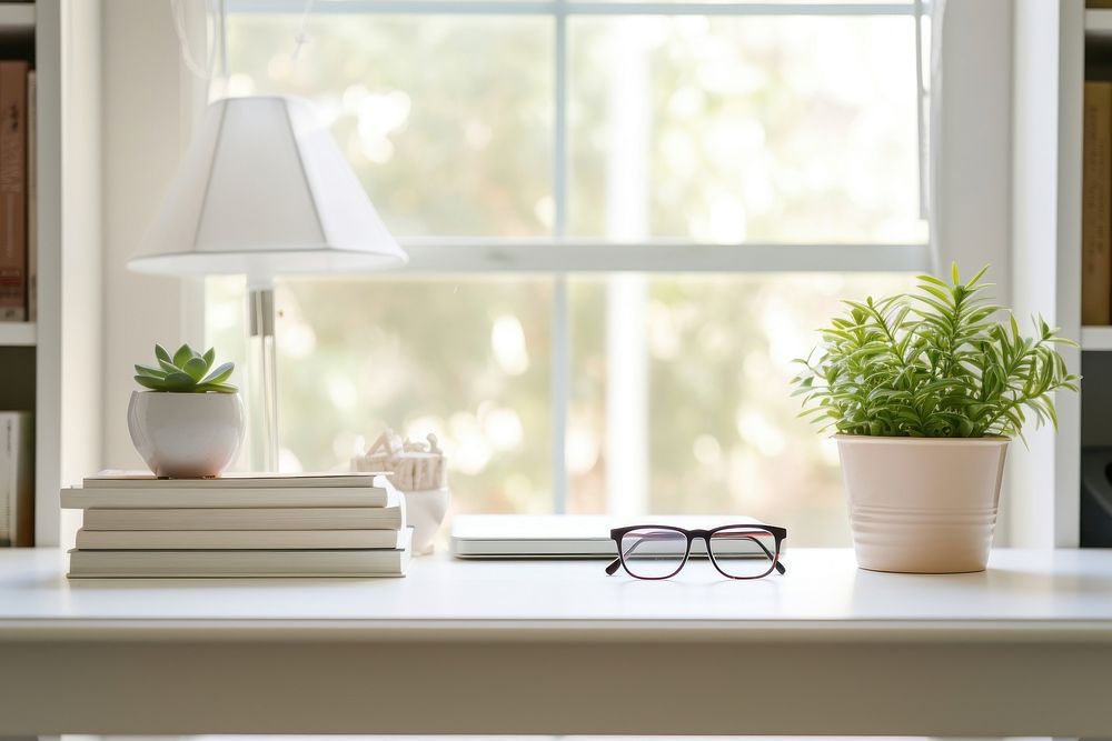 Long white study table plant windowsill glasses. 