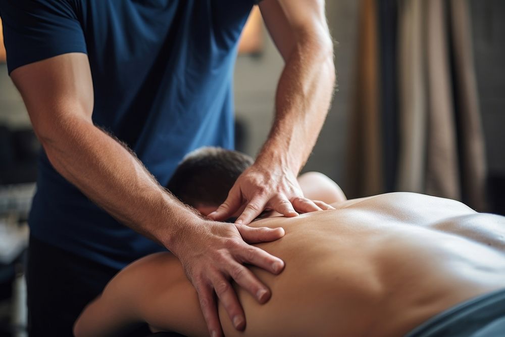 Therapist giving lower back sports massage patient adult male. AI generated Image by rawpixel.