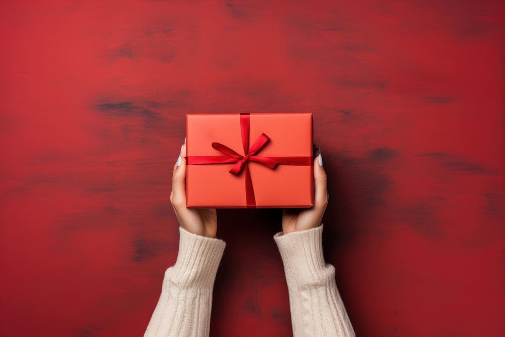 Christmas gift box holding hand red. AI generated Image by rawpixel.