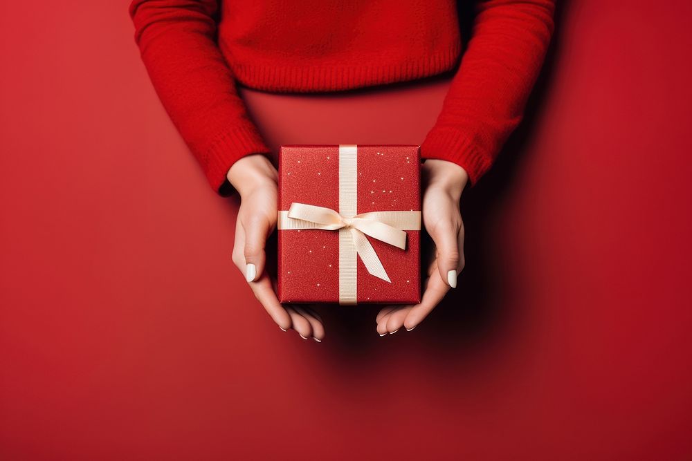 Christmas gift box holding hand red. AI generated Image by rawpixel.