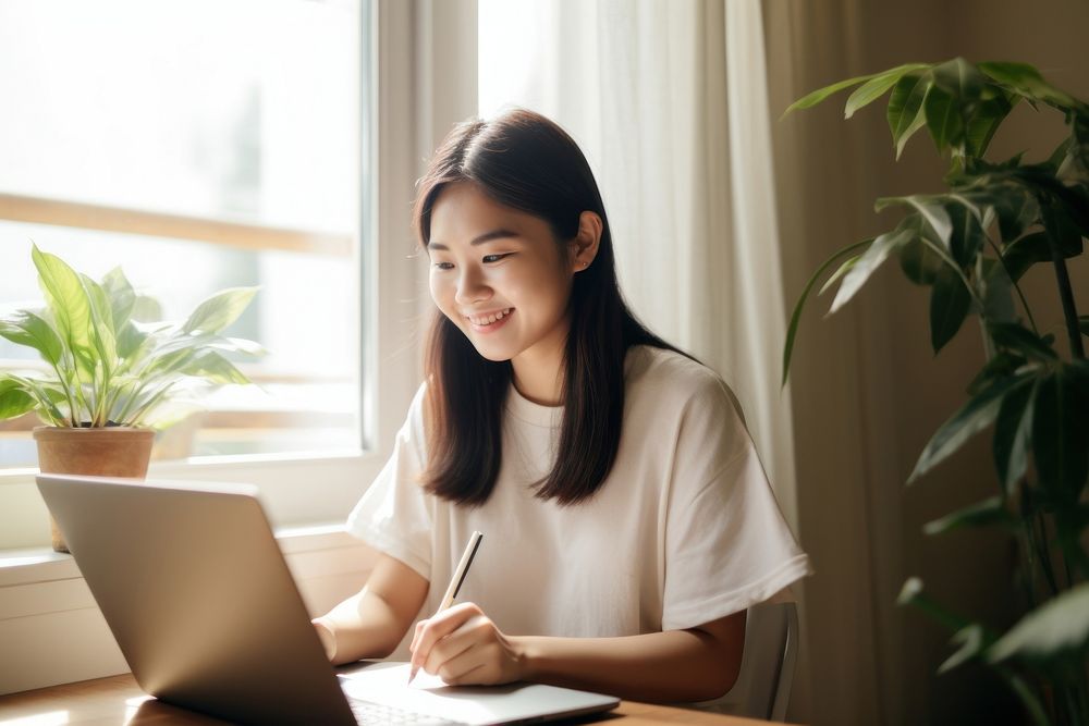 Smiling asian woman writing laptop computer. AI generated Image by rawpixel.