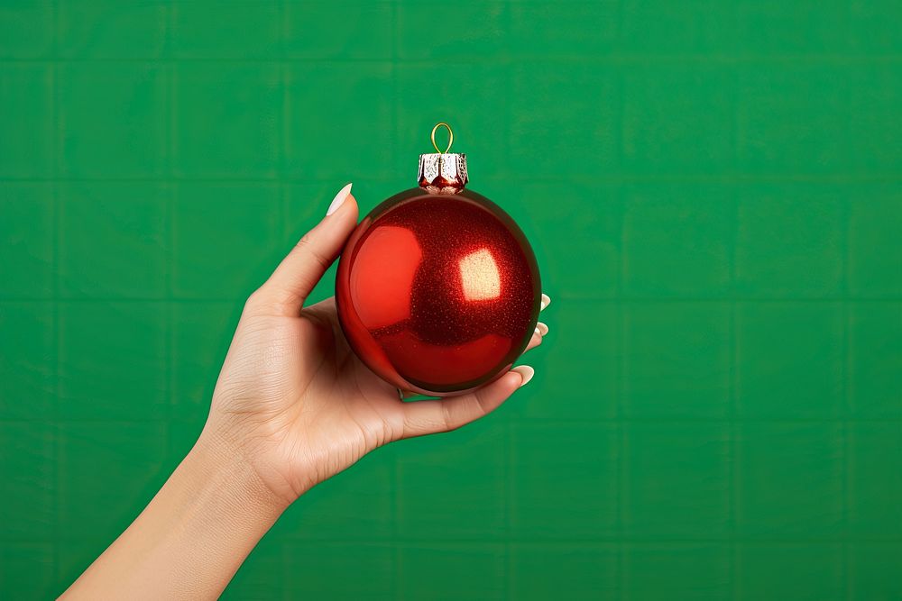 Christmas ornament holding green hand. AI generated Image by rawpixel.