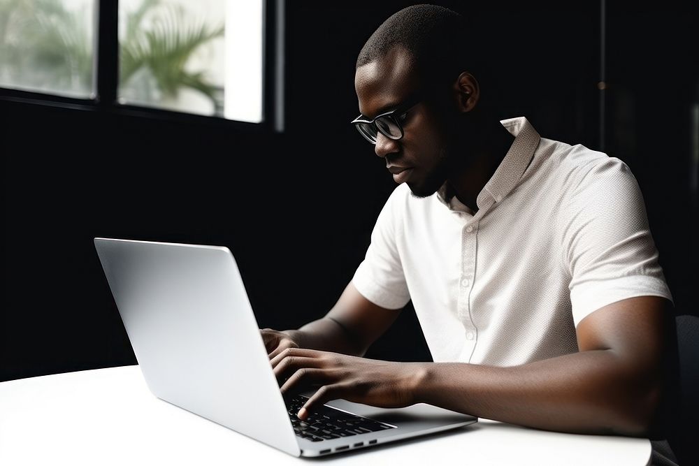 African American man laptop computer sitting. AI generated Image by rawpixel.